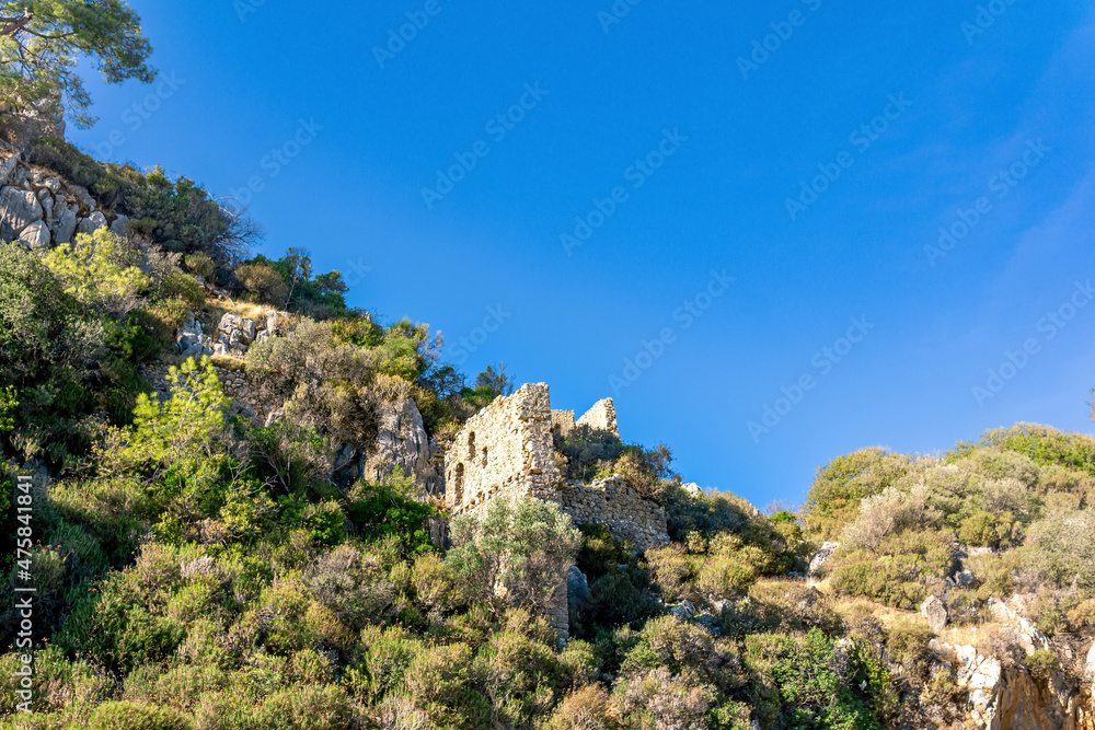 ruins of fortress walls on rocky mountain slopes near the antique city of Olympos, Turkey