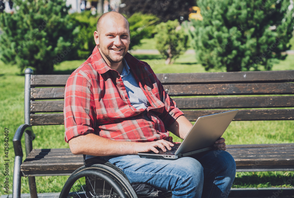 Obraz premium Freelancer with a physical disability who uses wheelchair working at the park