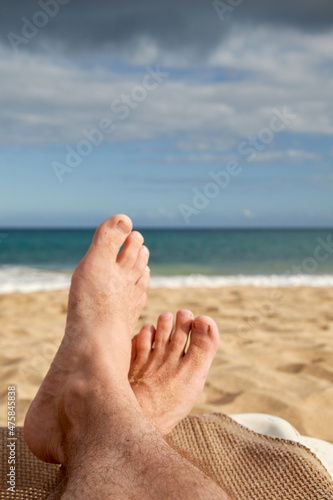 Feet on a beach lounger, no people, high angle