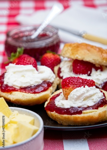 Close-up of scones with strawberry jam, cream and fresh strawberries