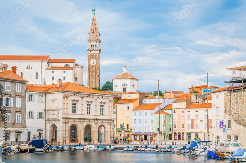 View on the Venetian style Piran main square with colorful historical houses and dominant church tower from a pier, Piran, Slovenia