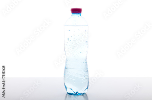 A bottle of sparkling water on the table. Plastic bottle with water on a white background. photo