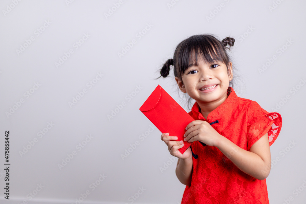 Happy Little Asian girl in Chinese traditional dress smiling and holding a red envelope. Happy Chinese new year concept. Happy Little Asian girl in Chinese traditional dress smiling and holding a red envelope. Happy Chinese new year concept.