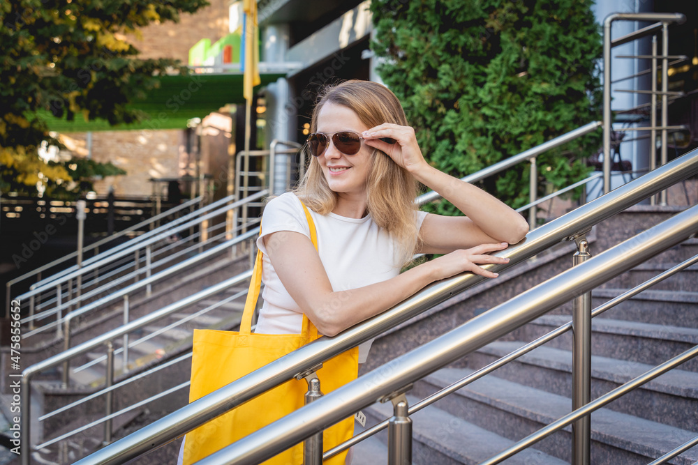 Fototapeta premium Young beautiful woman with linen eco bag on city background.