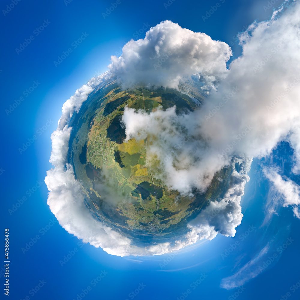 Naklejka premium Aerial view from high altitude of little planet earth covered with white puffy cumulus clouds on sunny day