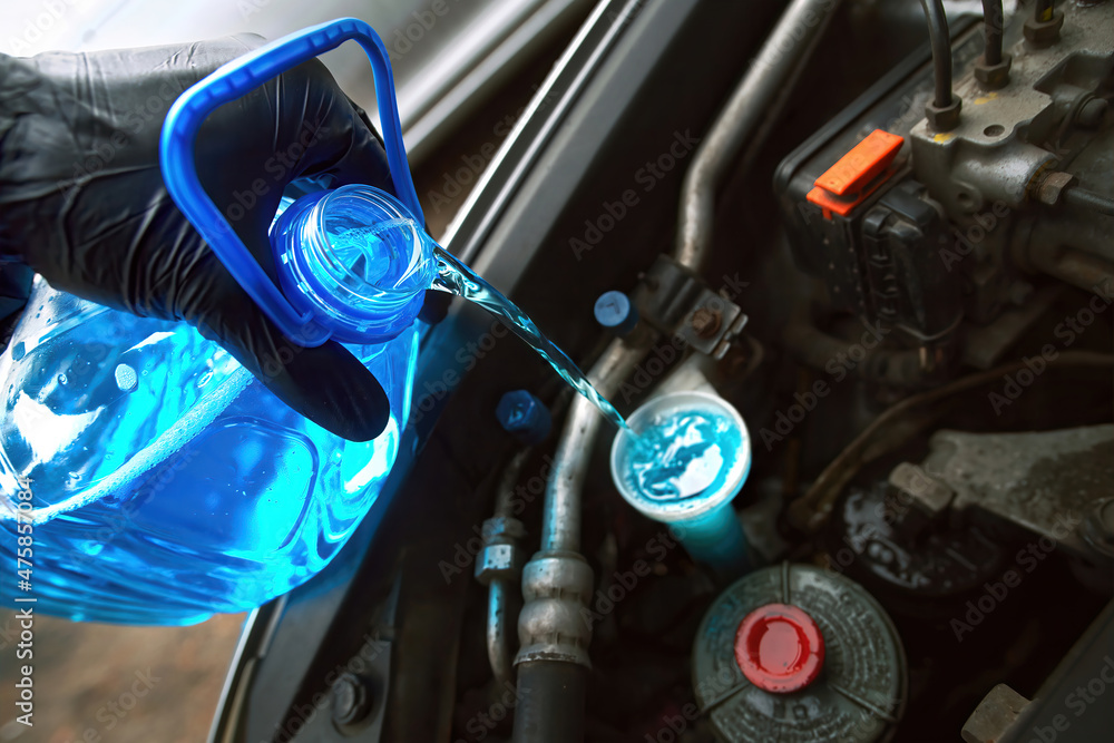 Man pouring winter windshield washer fluid. Pouring antifreeze liquid