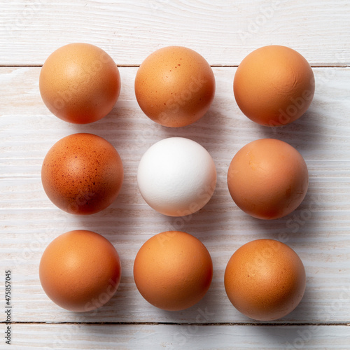 Nine eggs on a wooden background.