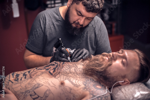 Master of the art of tattooing during a tattoo artist session tattoo studio photo