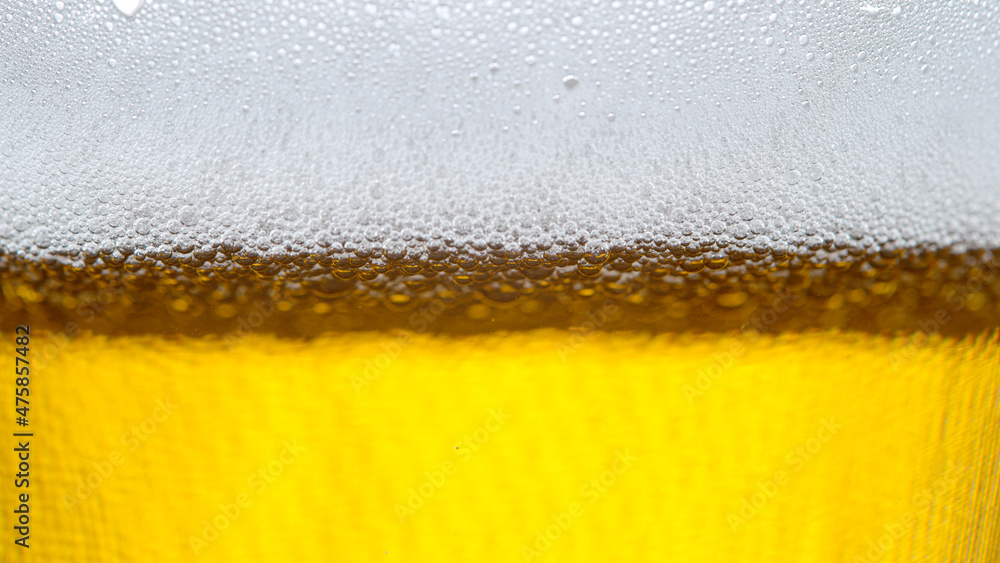 MACRO, DOF: Detailed macro of a foamy jug of refreshing non-alcoholic beer.