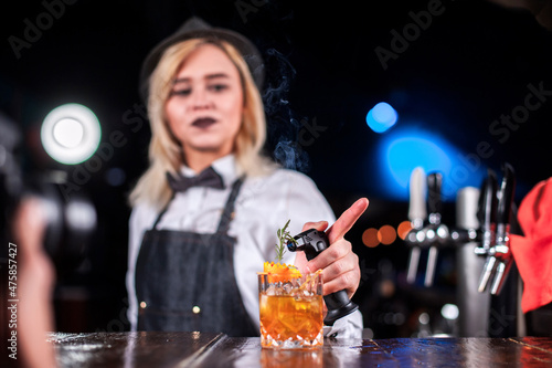 Girl barman creates a cocktail at the beerhouse photo