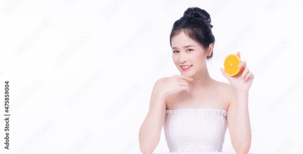 Joyful Asian woman holding freshness orange slices vitamin c for good skin looking at camera over isolated white background. Health care complexion vitality or diet lifestyle concept. Joyful Asian woman holding freshness orange slices vitamin c for good skin looking at camera over isolated white background. Health care complexion vitality or diet lifestyle concept.