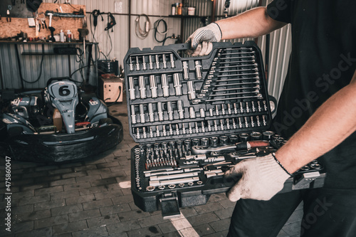 Karting service mechanic holds a set of mechanic's tools © romaset