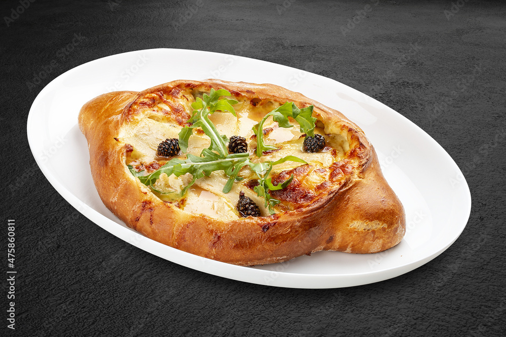 Traditional Georgian cuisine. Adjarian khachapuri. Isolated on a black background. Traditional Georgian cuisine. Adjarian khachapuri. Isolated on a black background.
