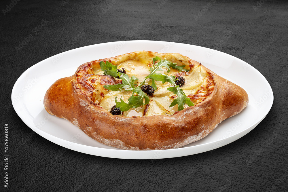 Traditional Georgian cuisine. Adjarian khachapuri. Isolated on a black background. Traditional Georgian cuisine. Adjarian khachapuri. Isolated on a black background.