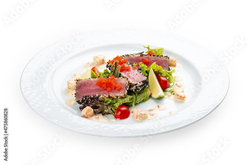 Tuna on a pillow of chuka with shrimp sauce . Isolated on a black background.