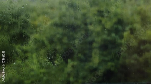 Raindrops on a window during summer rain showers.