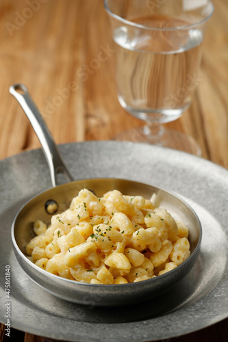 Creamy Macaroni and Cheese on a Skillet Oan with Parmesan and Herbs, Isolated on Wooden Table photo