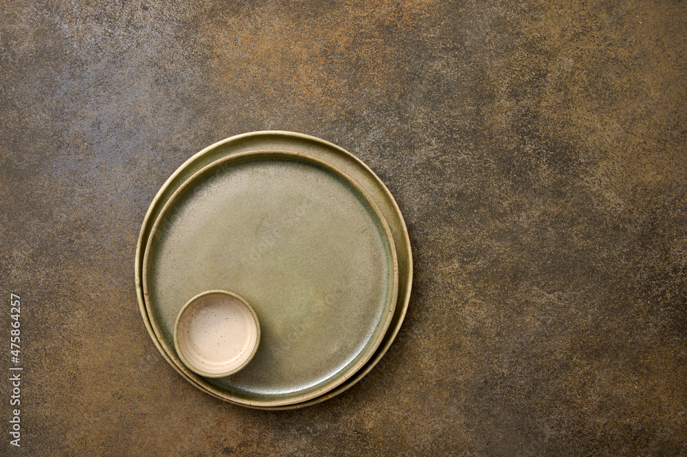Empty green ceramic two plates and saucepan one in one on rustic background, copy space, top view Empty green ceramic two plates and saucepan one in one on rustic background, copy space, top view