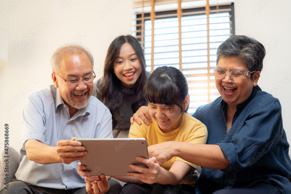 Laughing and smiling family enjoying social media with computer tablet pad