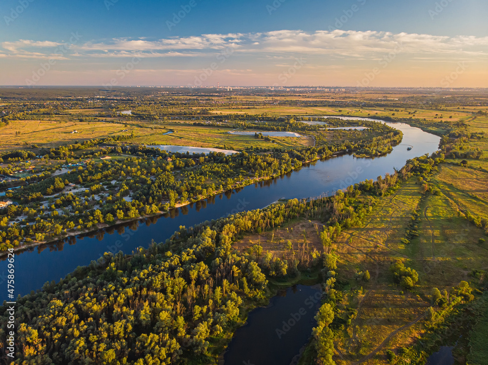 Aerial drone view. The bend of a wide river among green meadows.