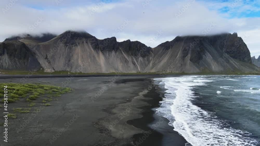 Iceland drone shot - Stokksnes on a cloudy day and dramatic waves with black sand Iceland drone shot - Stokksnes on a cloudy day and dramatic waves with black sand