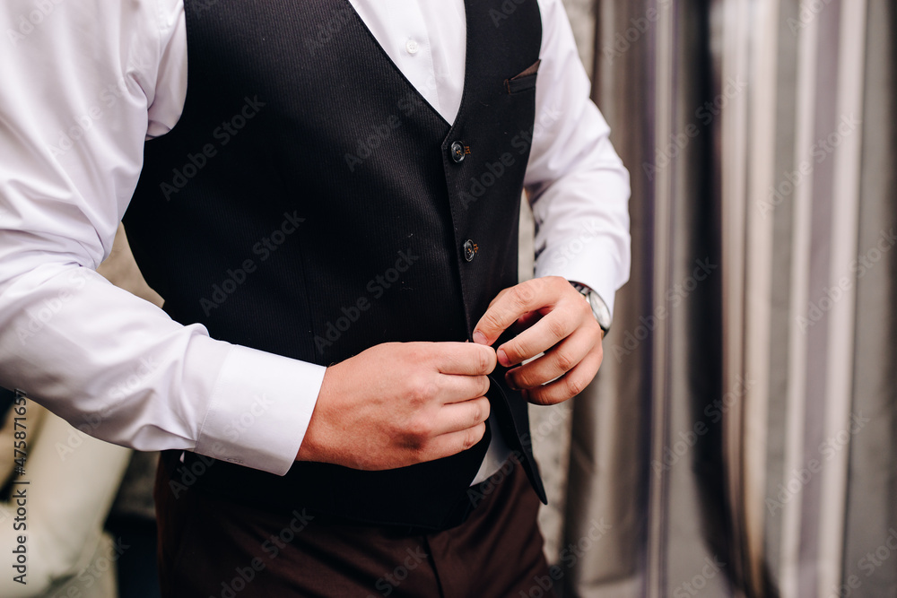 wedding, the groom gets dressed, fastens a button on his sleeve