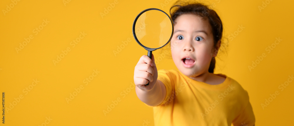 Portrait of surprised cute little asian girl looking through a magnifying glass. Education concept. Portrait of surprised cute little asian girl looking through a magnifying glass. Education concept.