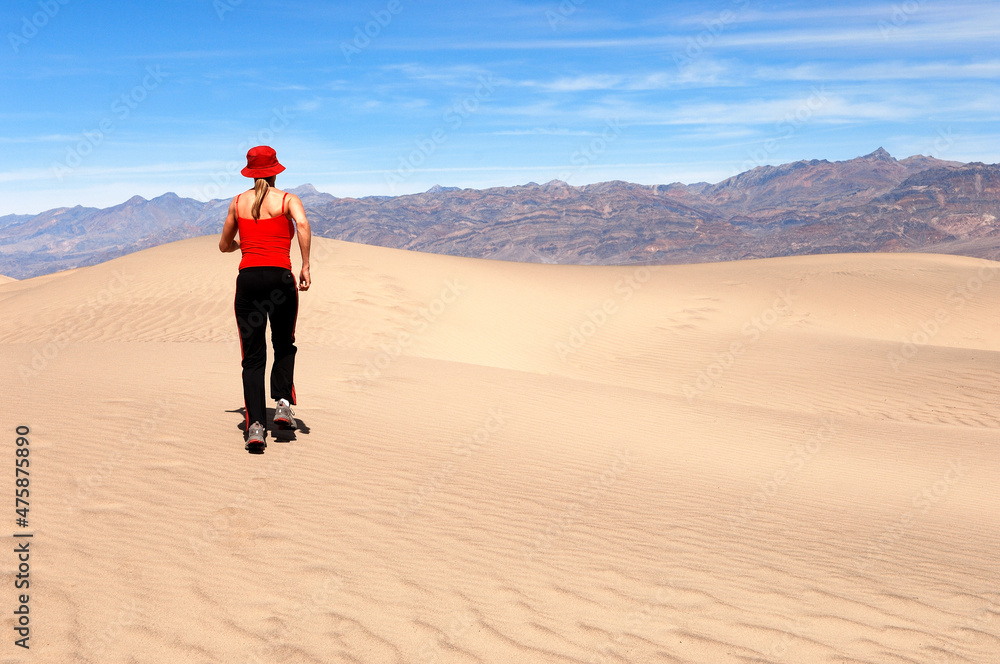 Female jogging along sand dune.