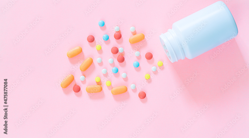 pills and pill bottles on pink background,Blue capsule pills spread out of white plastic drug bottle on pink background. Pharmacy banner. Online pharmacy. Painkiller medicine and antibiotic drug resis pills and pill bottles on pink background,Blue capsule pills spread out of white plastic drug bottle on pink background. Pharmacy banner. Online pharmacy. Painkiller medicine and antibiotic drug resis