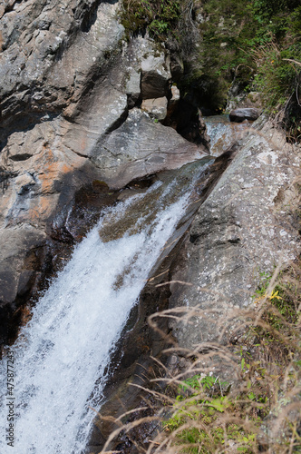 kleiner Wasserfall in bergiger  Landschaft an einem sonnigen Herbsttag © lucky  photographer