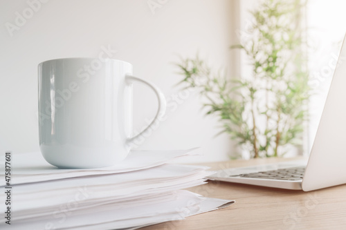 Coffee and office paperwork, a closeup shot of cup over forms and invoices