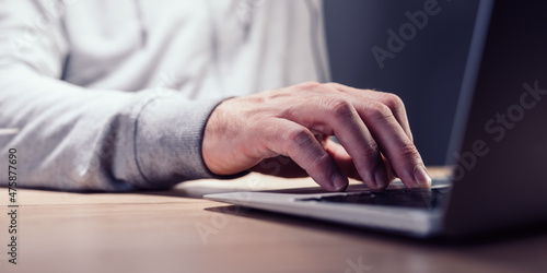 Closeup of male hand typing laptop computer keyboard