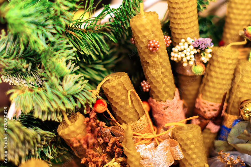 Beeswax candles decorated in Christmas style and a twig tree. Design for the new year.