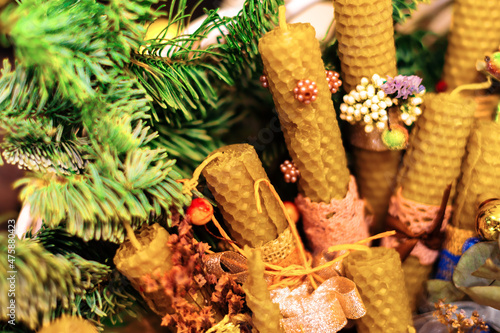 Obraz na płótnie Beeswax candles decorated in Christmas style and a twig tree. Design for the new year. w salonie