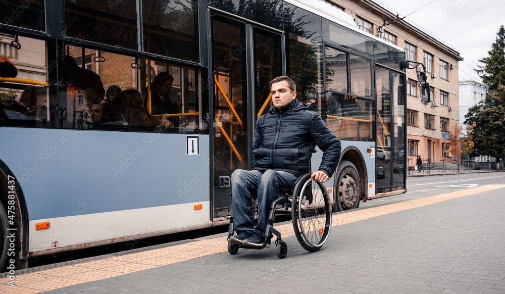 Obraz premium Person with a physical disability exits public transport with an accessible ramp.