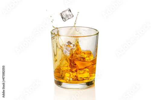 Glass of Whiskey, whisky or bourbon with falling ice cubes with splash, isolated on white