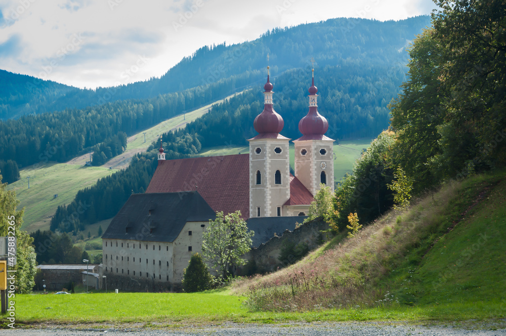 Blick auf eine Kirche mit zwei Türmen in einem Tal in der Steiermark