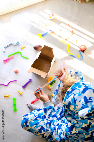 Kid in pajama playing with colorful educational toys during Christmas.