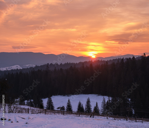 Small alpine village and winter snowy mountains in first sunrise sunlight around, Voronenko, Carpathian, Ukraine. © wildman