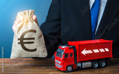 Businessman with Euro money bag and truck. High income of the transport business and the transport of goods. Rising prices, global containers shortage crisis. Logistics. Good salaries for drivers. photo