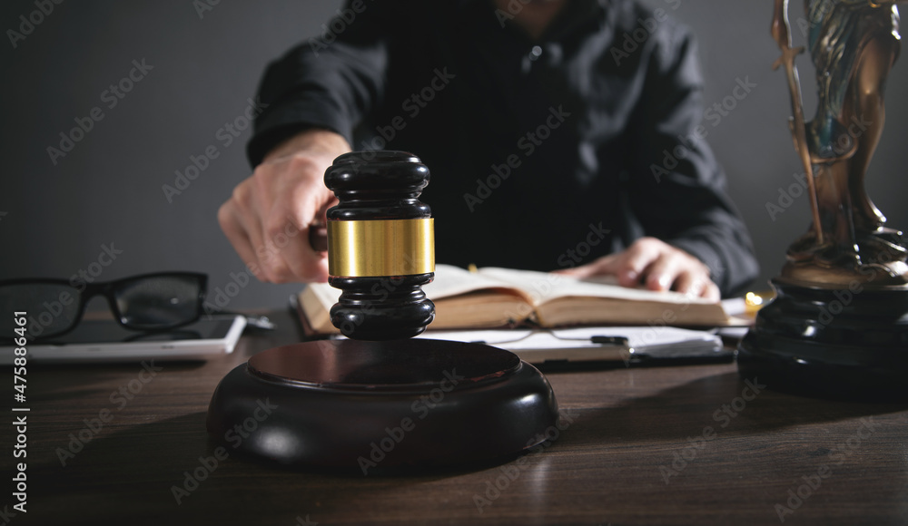 Male judge in a courtroom striking the gavel. Male judge in a courtroom striking the gavel.