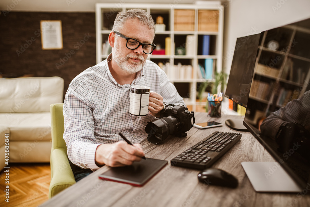 Photographer with beard, while working in his office at home. Photographer with beard, while working in his office at home.