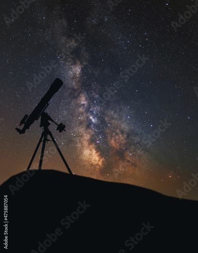 Silhouette of a telescope against the background of the Milky Way. The telescope is a refractor and the center of our galaxy. 