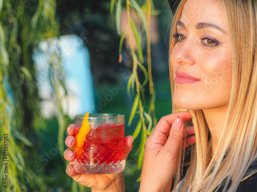 Female drinking a negroni campari aperol cranberry cocktail photo