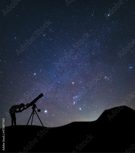 Silhouette of a telescope and a man watching the constellation Orion.  photo