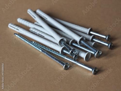 Stack with nail dowels. Impact dowels. Dowels and dowel nails. Group of dowels and nails on wooden background