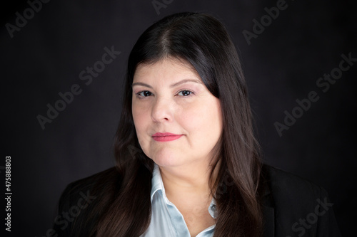 Professional lady poses for a headshot. She is elegant and look straight to the camera