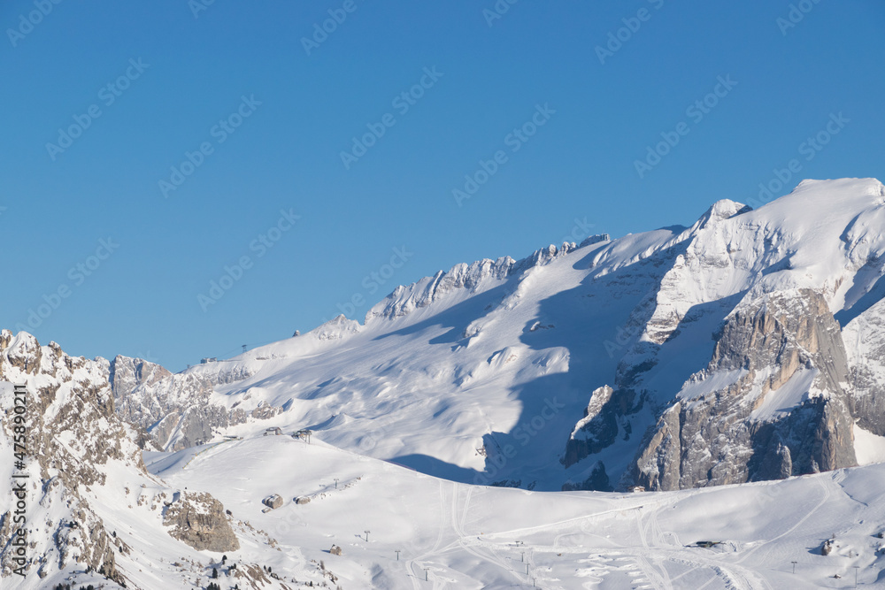 Panorama sul Ghiacciaio della Marmolada in inverno, paesaggio innevato verso le vette e le piste da sci di Canazei in Trentino