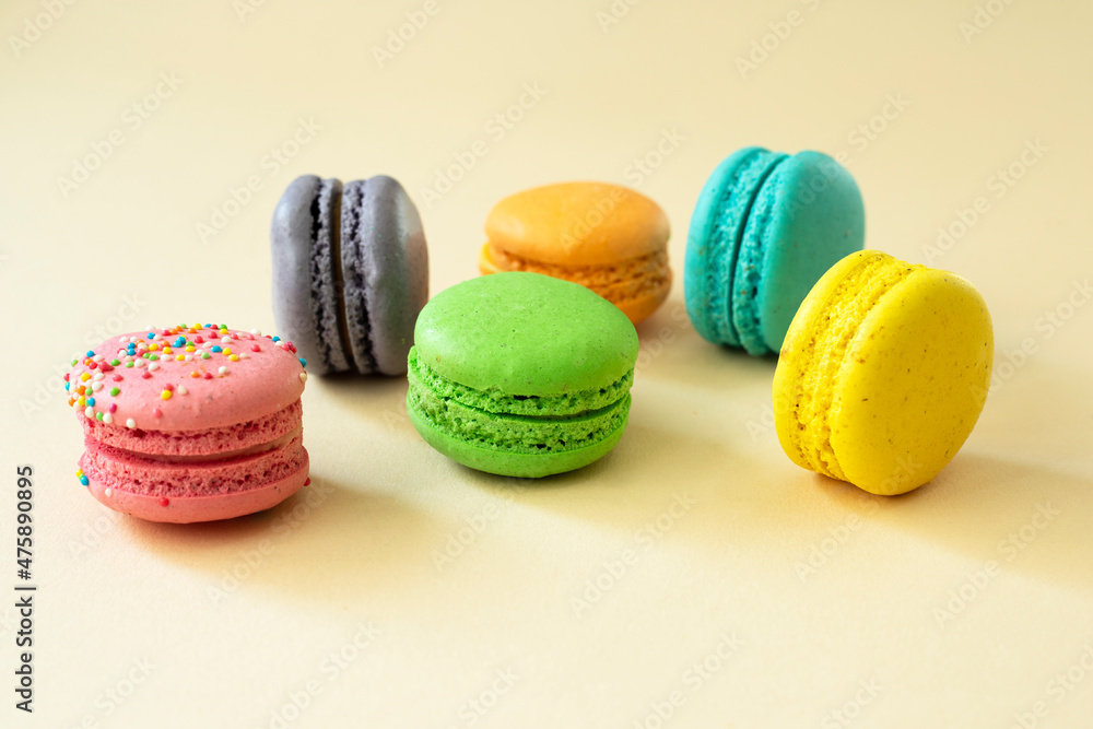 Sweet and colorful macarons on a yellow background, side view. Sweet and colorful macarons on a yellow background, side view.