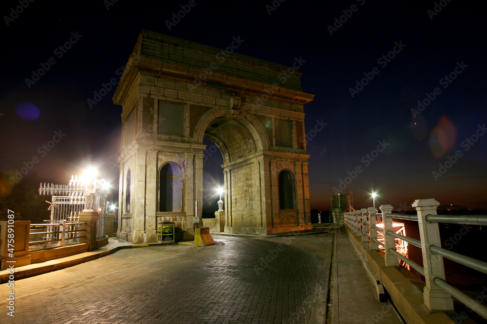 Fototapeta premium Cars driving over Arch on the dam wall at night with cars driving over in Hartbeespoort in the North West of South Africa